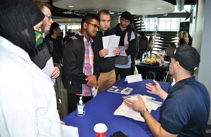 Business and IT students at info table